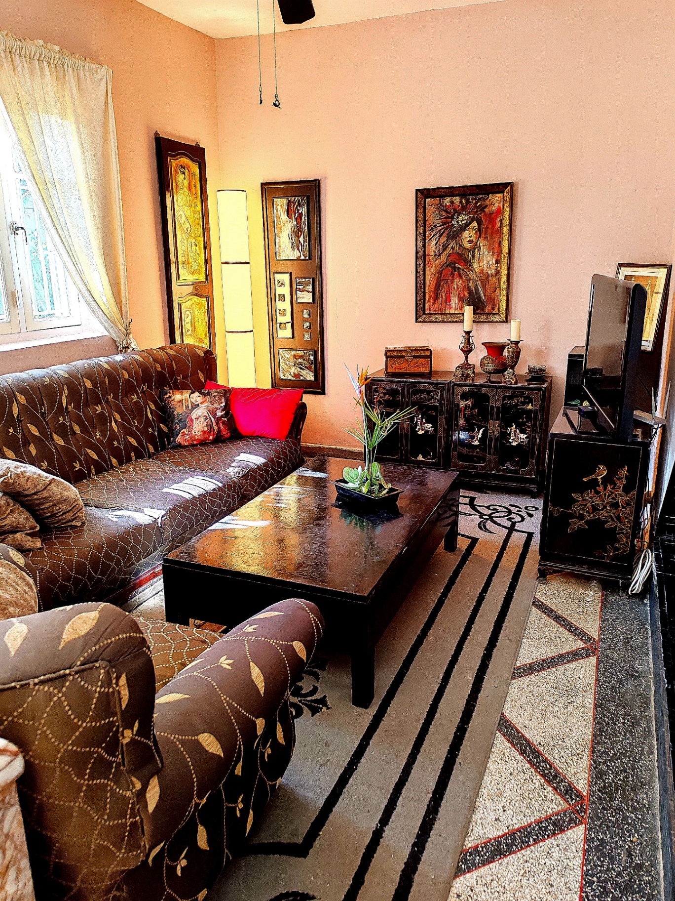 A first-floor salon with a television area and black lacquer cabinets.